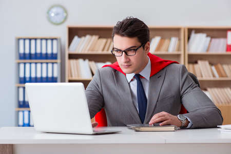 Superhero businessman working in the officeの写真素材