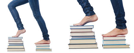 Student stepping on stack of booksの写真素材