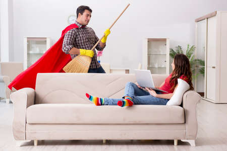 Superhero husband helping his wife at homeの写真素材