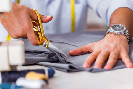 Young man tailor working on new clothing