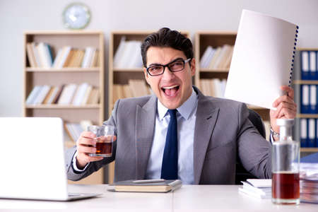 Young businessman drinking from stressの写真素材