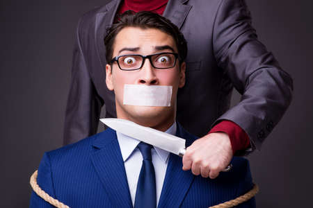 Businessman taken hostage and tied up with ropeの写真素材