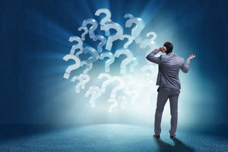 Businessman in uncertainty concept with question marksの写真素材