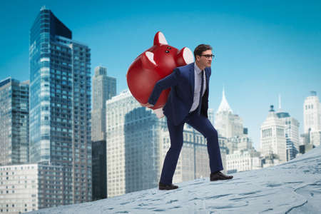 Businessman carrying the piggybank with savingsの写真素材
