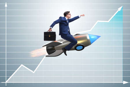 Businessman flying on rocket in business conceptの写真素材