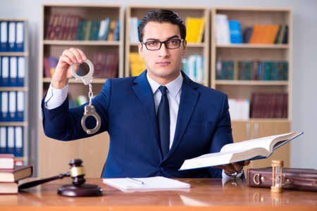 Handsome judge with gavel sitting in courtroomの写真素材