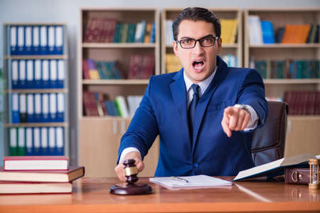 Handsome judge with gavel sitting in courtroomの写真素材