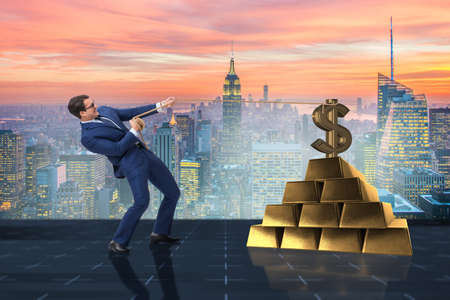 Businessman pulling dollar and gold bullionsの写真素材