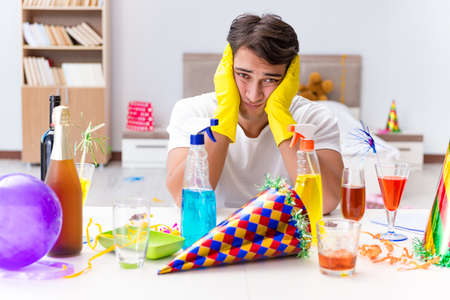 Man cleaning the house after christmas partyの写真素材