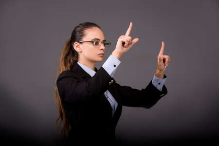 Young woman businesswoman pressing virtual buttonsの写真素材
