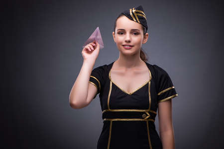 Young flight attendant on gray backgroundの写真素材