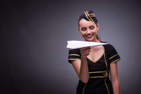 Young flight attendant on gray backgroundの写真素材