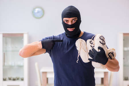 Robber wearing balaclava stealing valuable thingsの写真素材