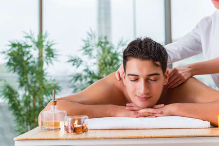Handsome man during spa massaging sessionの写真素材