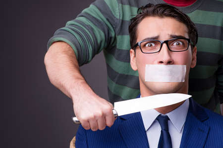 Businessman taken hostage and tied up with ropeの写真素材