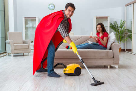 Superhero husband helping his wife at homeの写真素材