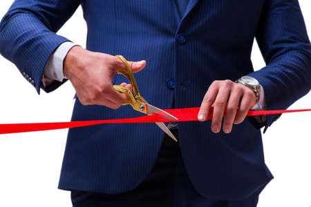 Businessman cutting red ribbon isolated on whiteの写真素材