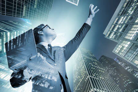 Businessman with laptop against the building