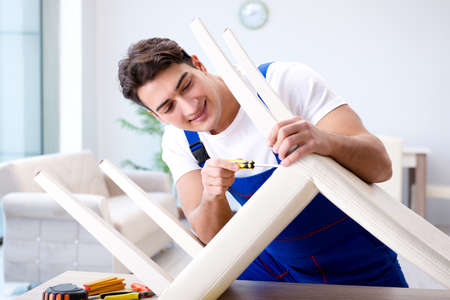 Man repairing chair in the roomの写真素材