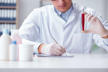 Young doctor in the lab with red tubeの写真素材
