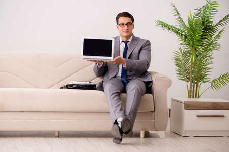 Businessman with laptop notebook sitting in sofaの写真素材