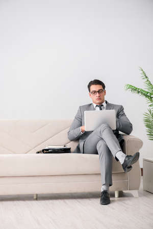 Businessman with laptop notebook sitting in sofaの写真素材