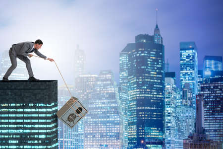 Businessman stealing safe from buildingの写真素材