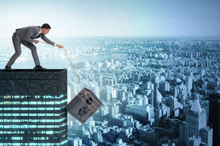 Businessman stealing safe from buildingの写真素材