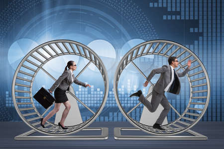 Business concept with pair running on hamster wheelの写真素材