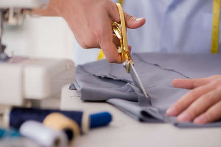 Young man tailor working on new clothing