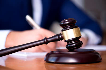 Handsome judge with gavel sitting in courtroom