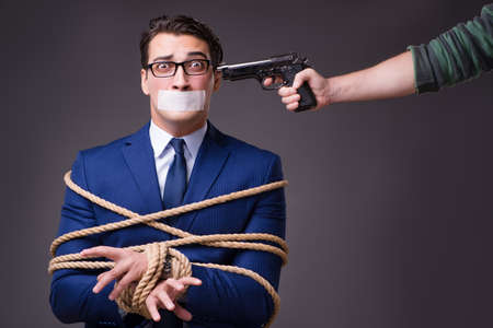 Businessman taken hostage and tied up with rope