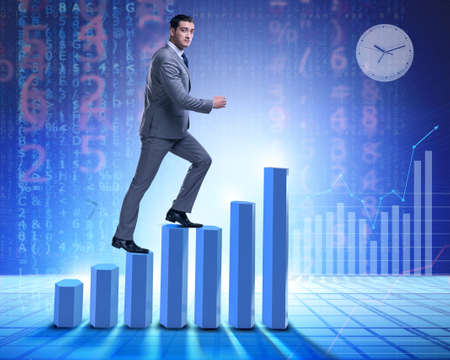 Businessman climbing bar charts in business conceptの写真素材
