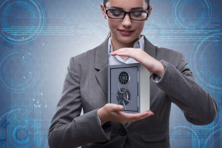 Businesswoman holding metal safe in security conceptの写真素材