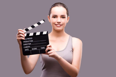 Woman with movie clapper on gray backgroundの写真素材