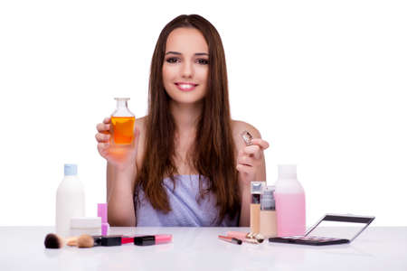 Woman doing makeup isolated on white
