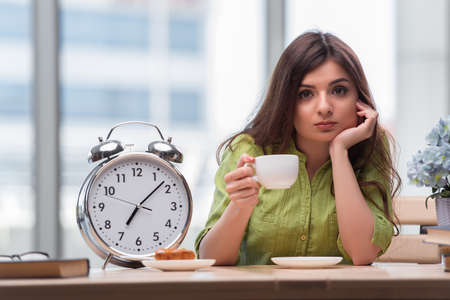 Student with gian alarm clock preparing for examsの写真素材