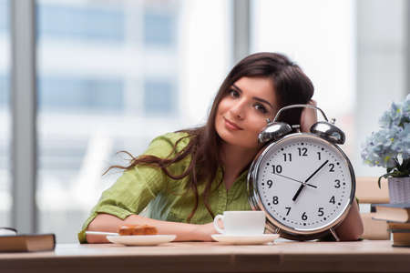 Student with gian alarm clock preparing for examsの写真素材