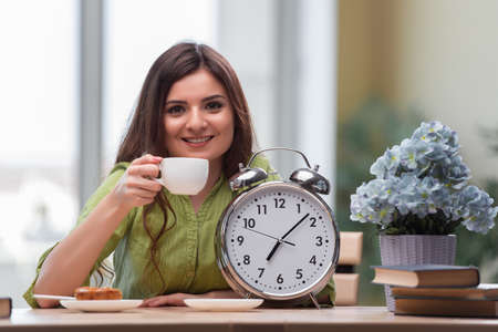 Student with gian alarm clock preparing for examsの写真素材