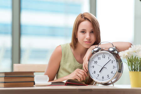 Student with gian alarm clock preparing for examsの写真素材
