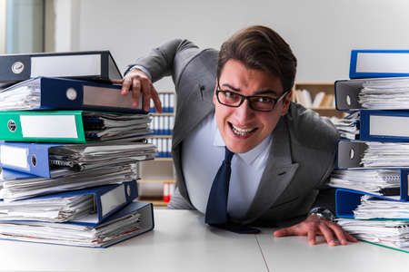 Businessman under stress due to excessive workの写真素材