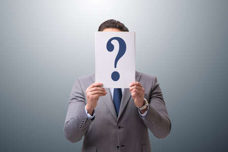 Businessman in uncertainty concept with question marksの写真素材