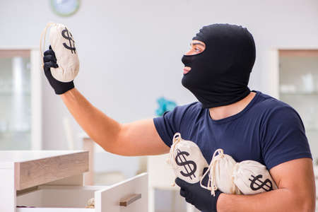 Robber wearing balaclava stealing valuable thingsの写真素材