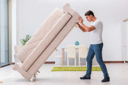 Man moving furniture at homeの写真素材