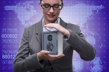 Businesswoman holding metal safe in security conceptの写真素材