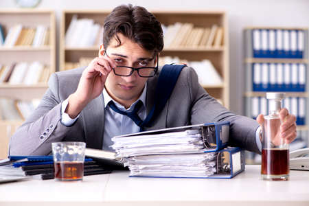 Young businessman drinking from stressの写真素材