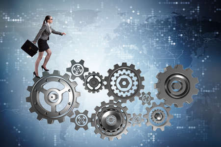 Woman businesswoman walking in cogwheelsの写真素材