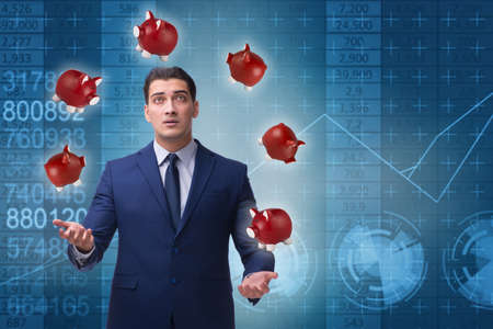 Businessman juggling with piggybanks in business conceptの写真素材