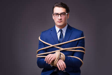 Businessman tied up with ropeの写真素材