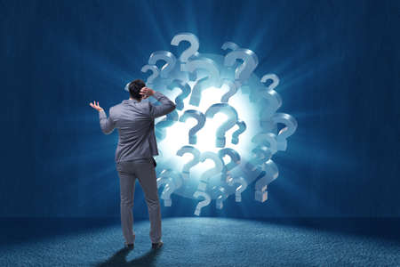 Businessman in uncertainty concept with question marks